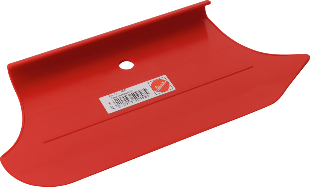 Un lisseur pour papier peint en plastique rouge vif sur fond blanc. L'outil présente une large surface légèrement courbée aux extrémités arrondies, un rebord relevé sur un côté et un trou rond pour l'accroche au centre. Un autocollant rectangulaire portant un code-barres et des informations produit est apposé sur la face. La surface plastique brillante reflète la lumière; la forme est destinée à lisser le papier peint, aplatir les joints et éliminer les bulles d'air.