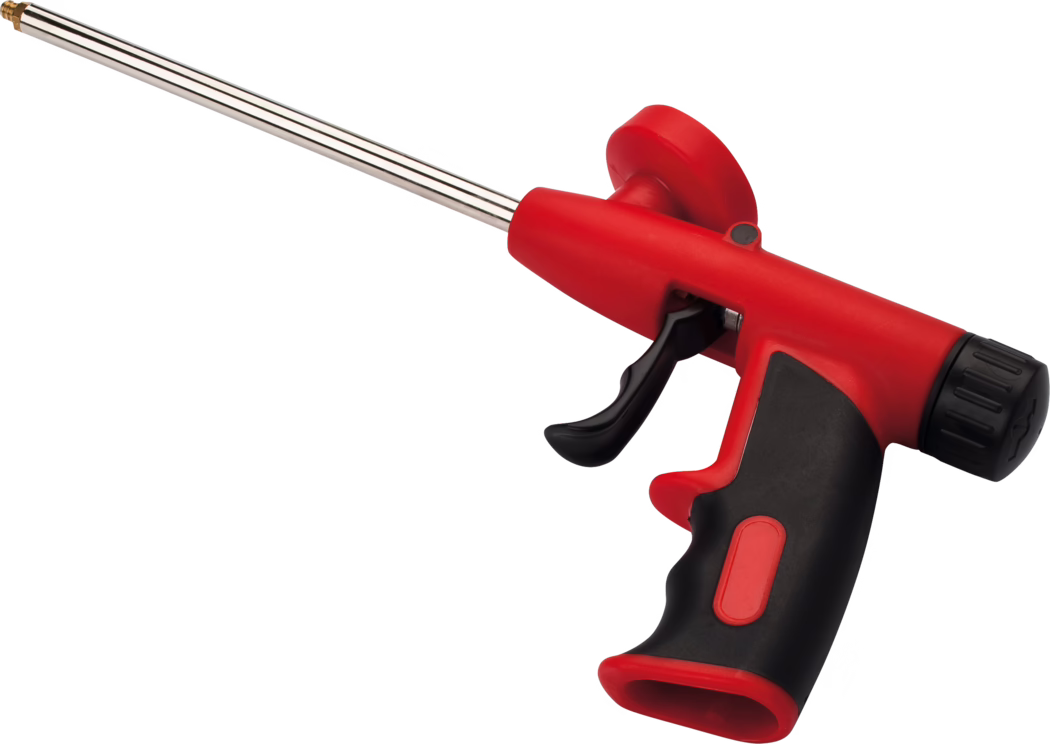 Pajarito_Dummy_Filling foam gun Easy Line_021286_2021-02 Gros plan d'un pistolet à cartouche rouge et noir avec une longue buse argentée, montrant la poignée ergonomique, la gâchette et la bague de rotation de la buse sur fond blanc.