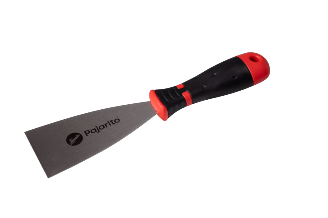 Photo produit d'une spatule métallique avec une large lame en acier inoxydable portant la marque "Pajarito" et un manche ergonomique en caoutchouc noir et rouge avec trou de suspension, présentée sur fond blanc ; adaptée au grattage, à l'enduisage et au rebouchage.