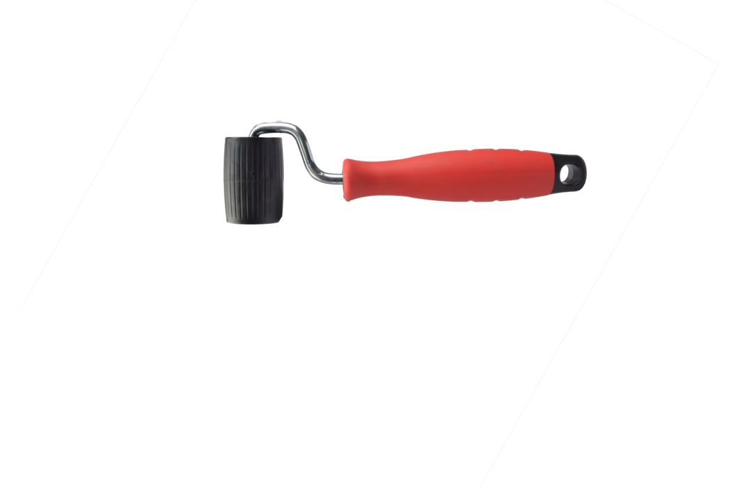 Pajarito_Dummy_Seam roller barrel shape Performance Line_034760_2021-02 Un petit rouleau à main avec une poignée ergonomique en plastique rouge, une courte tige métallique chromée incurvée et un cylindre en caoutchouc noir nervuré à l'extrémité, photographié sur fond blanc. Le rouleau semble conçu pour lisser ou presser des matériaux le long des joints et présente de légères traces d'usure ; la poignée comporte un trou pour l'accrochage.