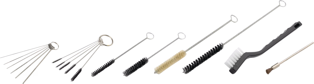 Une disposition horizontale d'outils de nettoyage variés sur fond blanc. De gauche à droite : plusieurs tiges métalliques fines en forme d'aiguille sur un anneau, un lot de cinq micro-brosses torsadées sur un porte-clés, plusieurs brosses droites pour bouteilles et tubes à tige métallique torsadée avec des poils noirs ou beige de diamètres différents, une longue brosse flexible à poils noirs denses, une brosse à manche en plastique noir avec des poils en nylon blancs, et une petite brosse à pointe laiton aux poils courts et raides. Les outils présentent des tiges métalliques argentées et des manches en fil torsadé, conçus pour le nettoyage détaillé de tubes, buses, valves, petites pièces et pour l'entretien d'instruments ou travaux manuels. L'éclairage est uniforme et les ombres minimales, mettant en valeur la forme, la texture et les détails des poils.