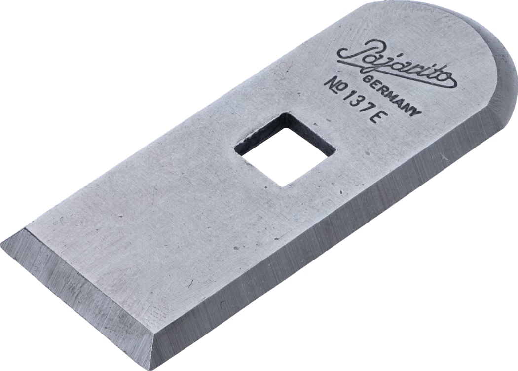 Une lame métallique rectangulaire unique avec un tranchant biseauté et un trou de fixation carré au centre ; l'extrémité supérieure est arrondie et gravée « Pajarito GERMANY No 137 E ». Surface en acier mate avec des traces d'usinage visibles.