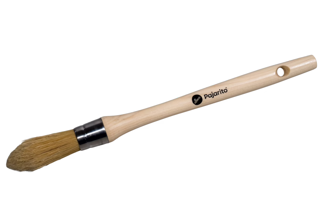Pajarito_Dummy_xx_Pointed Brush Nature Mix_2024-07 Un pinceau rond à manche en bois clair, avec des poils naturels beige effilés en une pointe arrondie, maintenus par une virole métallique brillante. Le manche clair comporte un trou d'accrochage à l'extrémité et la marque 'Pajarito' imprimée en noir. Le pinceau semble propre et non utilisé, photographié isolé sur fond blanc ; adapté aux travaux de précision et au vernissage.