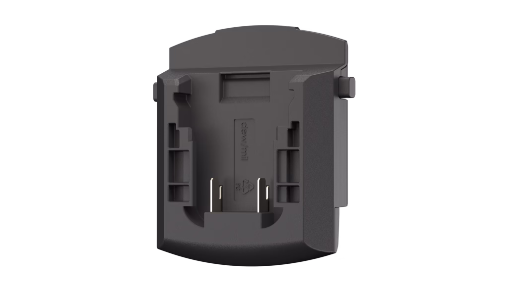Pajarito_Dummy_Adapter DeWalt_181137_2024-08 Adaptateur/porte-pile en plastique noir mat vu de face, montrant une cavité rectangulaire avec deux contacts métalliques exposés en bas, des rails de guidage et des loquets latéraux, un bord inférieur incurvé et des éléments d'assemblage en retrait ; surface texturée et petit symbole de recyclage embossé visibles.