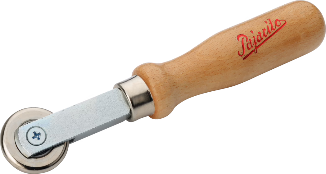 Gros plan d'une petite roulette à main avec un manche en bois lisse et une roue en métal. Le manche en hêtre clair porte le nom de marque « Pajarito » en écriture rouge ; une bague métallique relie le manche à un court bras métallique et à une roue circulaire en acier, utilisée pour lisser ou presser des coutures ou des matériaux. L'outil est photographié sur fond blanc.