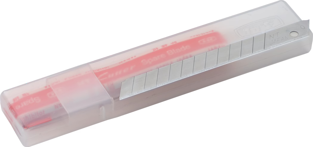 Vue rapprochée d'un boîtier en plastique translucide contenant une lame de rechange segmentée pour cutter. Le boîtier rectangulaire et translucide laisse apparaître une glissière intérieure rouge et une lame métallique argentée partiellement sortie, avec plusieurs traits de rupture pour détacher les segments ; la lame porte l'inscription « NT JAPAN ». Le boîtier à angles arrondis possède un couvercle coulissant et est photographié sur fond blanc, mettant en valeur la surface métallique brillante et la cartouche compacte de lames de rechange.
