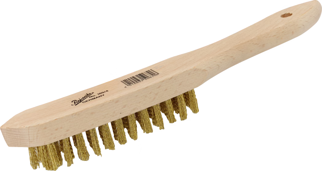 Pajarito_Dummy_Brass wire brush_034752_034753_034754_034755_014380_2021-02 Brosse métallique à main avec un manche en bois clair et lisse et une rangée de poils métalliques torsadés de couleur laiton. Le bloc de bois allongé se prolonge par une poignée ergonomique arrondie, avec un trou près de l’extrémité pour l’accrochage. Sur la face supérieure du manche apparaissent un logo imprimé de la marque et un code-barres. Les poils métalliques sont disposés en plusieurs touffes courtes, gaufrés et légèrement irréguliers aux extrémités, adaptés au nettoyage intensif et à l’élimination de la rouille, de la peinture ou de la saleté sur des surfaces métalliques. Le bois présente un aspect naturel non traité avec le veinage visible. La brosse est photographiée sur fond blanc et inclinée légèrement.