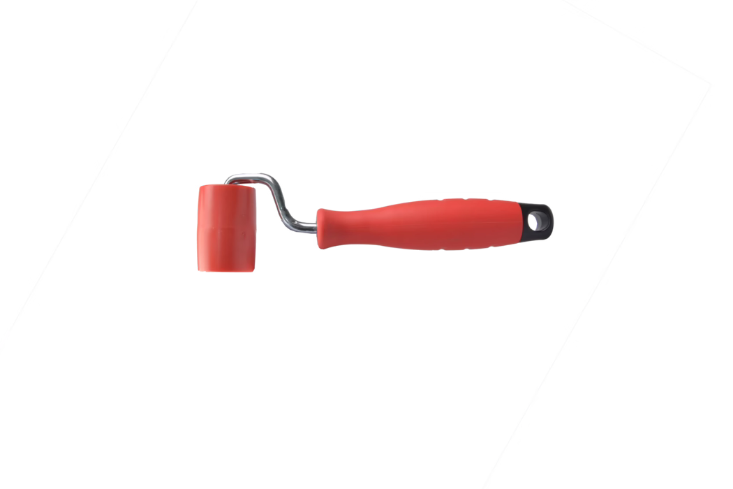 Petit rouleau manuel avec un tambour en caoutchouc rouge vif monté sur un court support métallique chromé et une poignée ergonomique en plastique rouge avec embout noir et trou de suspension. La tête du rouleau est en caoutchouc lisse, adaptée pour exercer une pression, lisser les joints de papier peint ou travailler avec des adhésifs et des surfaces de bricolage ; la construction compacte le rend utile pour les travaux de détail et les zones étroites. L'outil est photographié sur un fond blanc uni, la poignée pointant vers la droite et la tête vers la gauche.