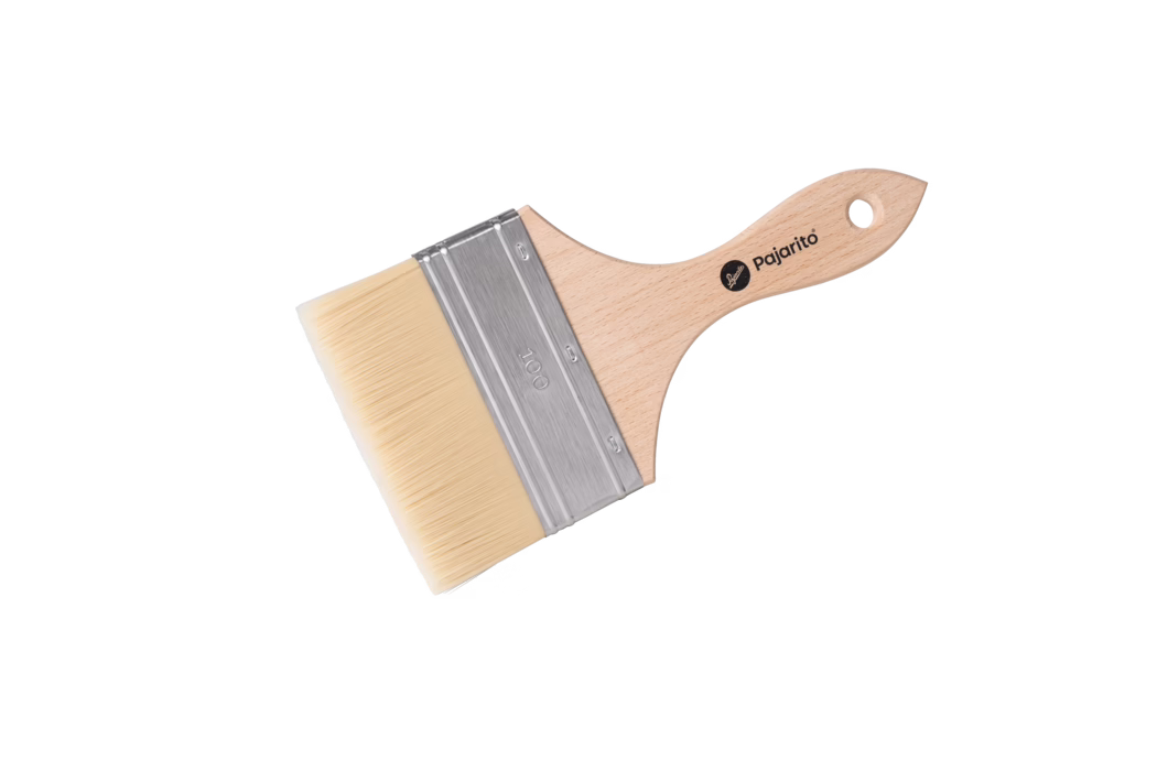 Pajarito_Dummy_Finish brush fine P-Line_179111_2024-02 Photo produit haute résolution d'un large pinceau plat présenté en diagonale sur fond blanc. Le pinceau comporte un manche en bois clair et lisse, courbé pour l'ergonomie avec un trou de suspension, un logo Pajarito estampé, une grande virole métallique argentée gravée 100, et des poils synthétiques pâles et serrés, taillés droit. L'éclairage uniforme met en valeur le grain du bois, la brillance métallique de la virole et le détail fin des poils.